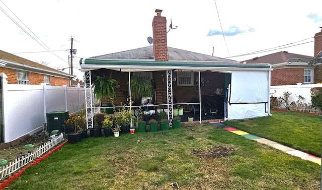 rear view of property featuring a lawn