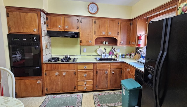 kitchen with backsplash, sink, and black appliances