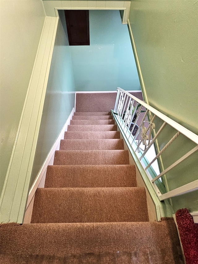 stairway featuring carpet flooring