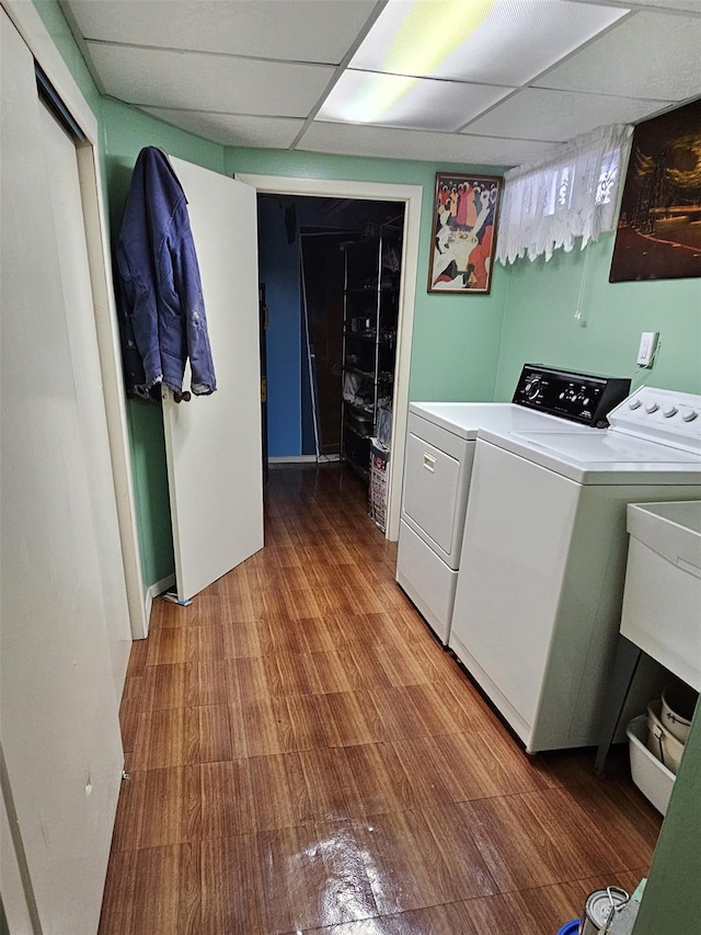 laundry area with washer and dryer, wood-type flooring, and sink