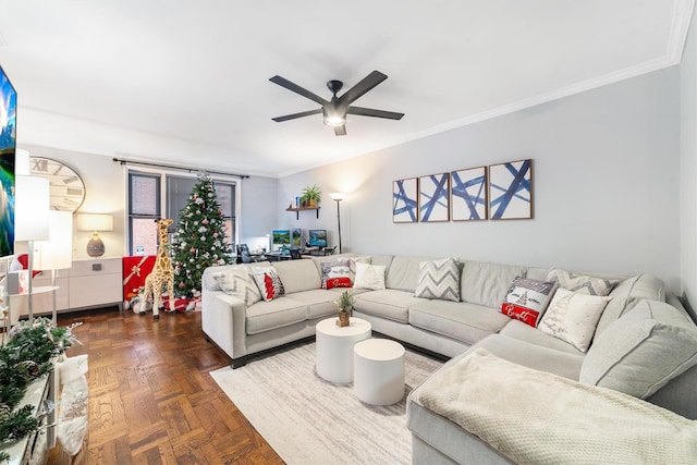 living room with dark parquet flooring, ceiling fan, and ornamental molding