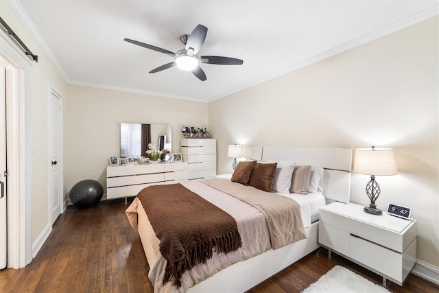 bedroom with a barn door, dark hardwood / wood-style floors, ceiling fan, and ornamental molding