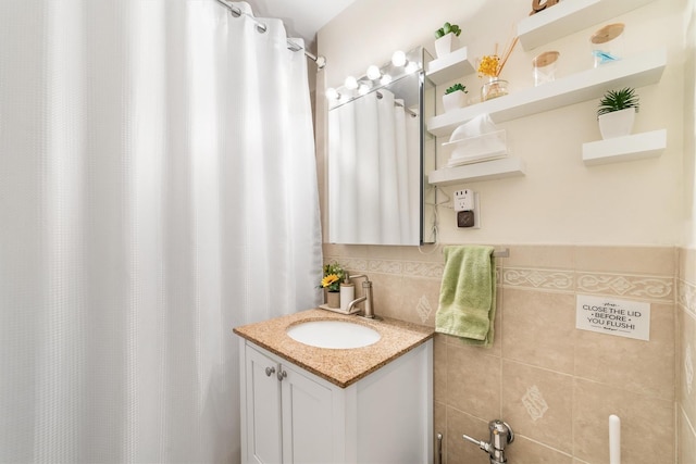 bathroom featuring vanity and tile walls