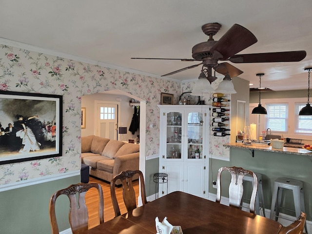 dining area featuring hardwood / wood-style flooring, ceiling fan, and crown molding