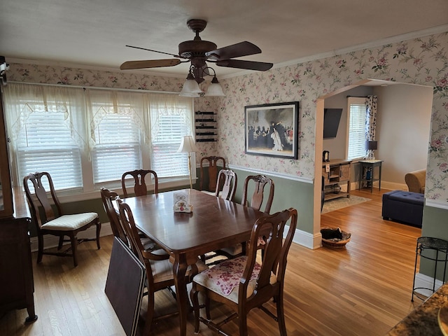 dining space with hardwood / wood-style flooring, ceiling fan, and ornamental molding