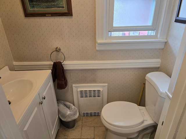 bathroom featuring toilet, vanity, heating unit, and tile patterned floors