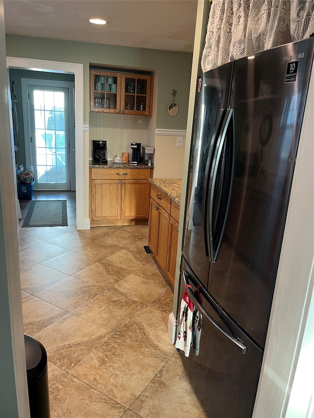 kitchen with light stone countertops and stainless steel fridge