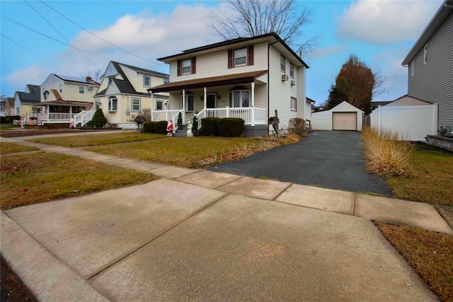 view of front of property featuring an outbuilding, a front lawn, covered porch, and a garage