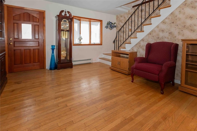 foyer featuring light wood-type flooring, stairs, and baseboard heating