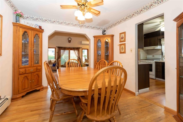 dining room featuring a wall mounted air conditioner, ceiling fan, light hardwood / wood-style flooring, and a baseboard heating unit