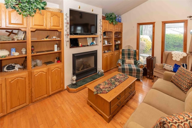 living room with light wood-type flooring and vaulted ceiling