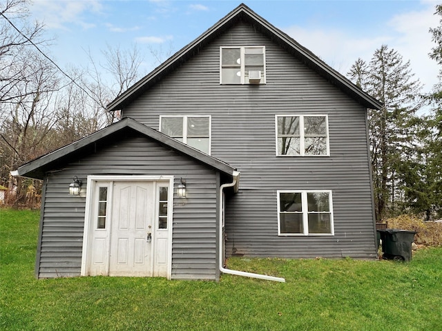 rear view of property featuring a lawn