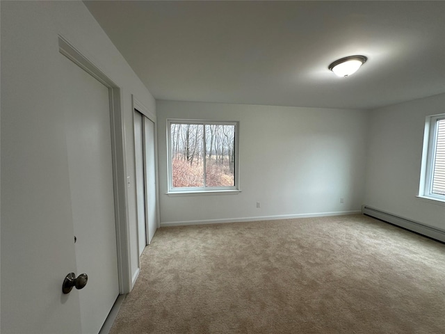 carpeted spare room with a baseboard radiator