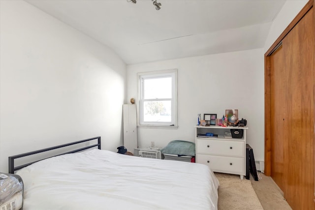 carpeted bedroom featuring a closet and lofted ceiling