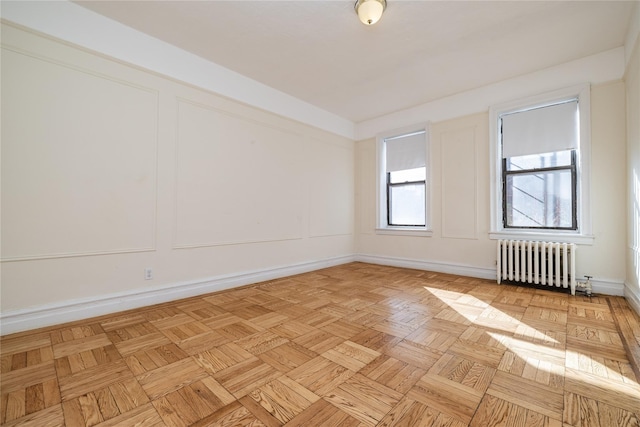 spare room with light parquet floors and radiator