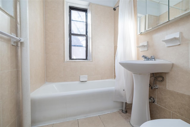 bathroom with tile patterned flooring, shower / bath combo, toilet, and tile walls