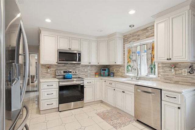 kitchen featuring backsplash, stainless steel appliances, sink, decorative light fixtures, and white cabinets