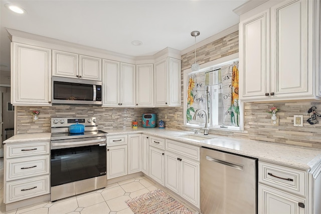 kitchen featuring pendant lighting, backsplash, sink, light tile patterned floors, and stainless steel appliances