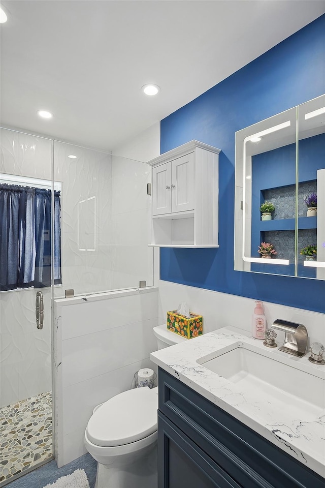 bathroom with toilet, an enclosed shower, and vanity