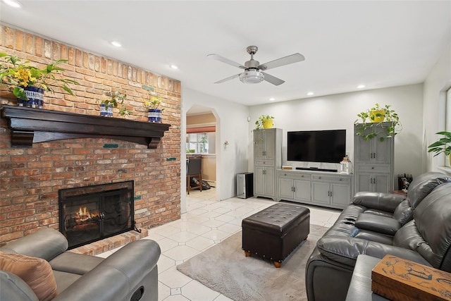 living room with ceiling fan and a fireplace