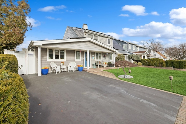 view of front facade featuring covered porch and a front yard