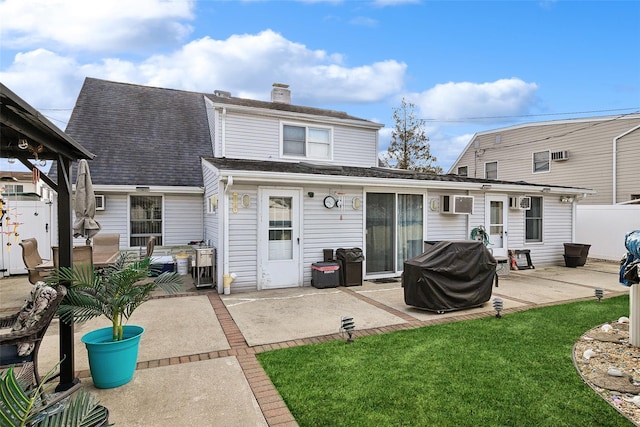 rear view of house with a patio area and a lawn