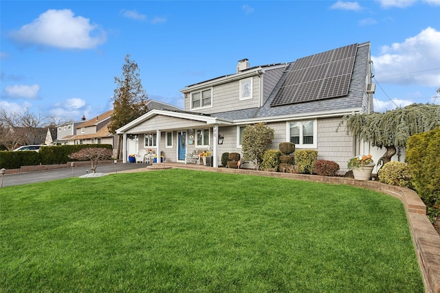 view of front of house featuring solar panels, a porch, and a front lawn