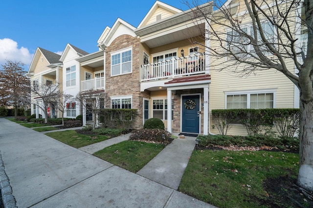 multi unit property with a front yard and a balcony