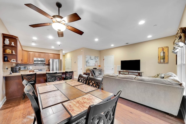 dining space with light wood-type flooring and ceiling fan