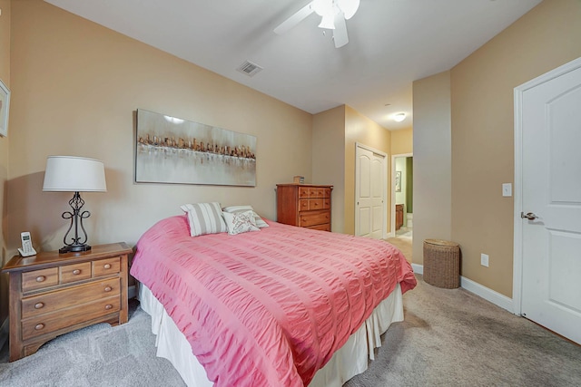 bedroom featuring ceiling fan, light carpet, connected bathroom, and a closet