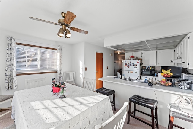 dining space with light colored carpet and ceiling fan