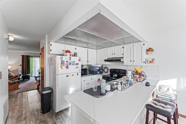 kitchen featuring black appliances, white cabinets, kitchen peninsula, and backsplash