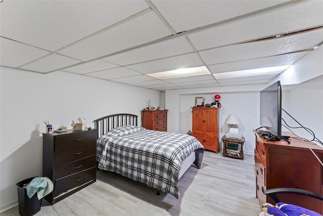 bedroom featuring a paneled ceiling and light wood-type flooring