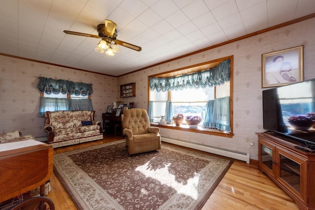 living area with ceiling fan, light hardwood / wood-style flooring, a baseboard radiator, and ornamental molding