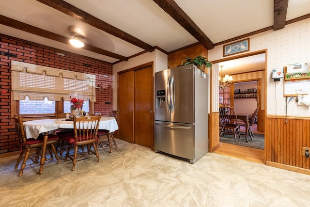 kitchen featuring beamed ceiling, stainless steel fridge, light wood-type flooring, and wooden walls