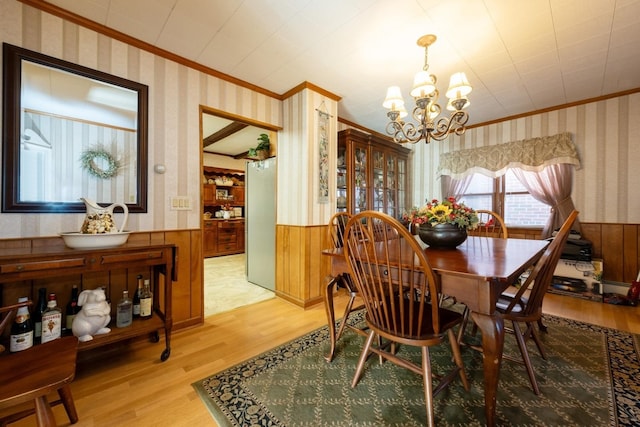 dining room featuring crown molding, hardwood / wood-style floors, and a chandelier