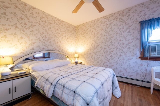 bedroom featuring a baseboard heating unit, cooling unit, ceiling fan, and dark wood-type flooring