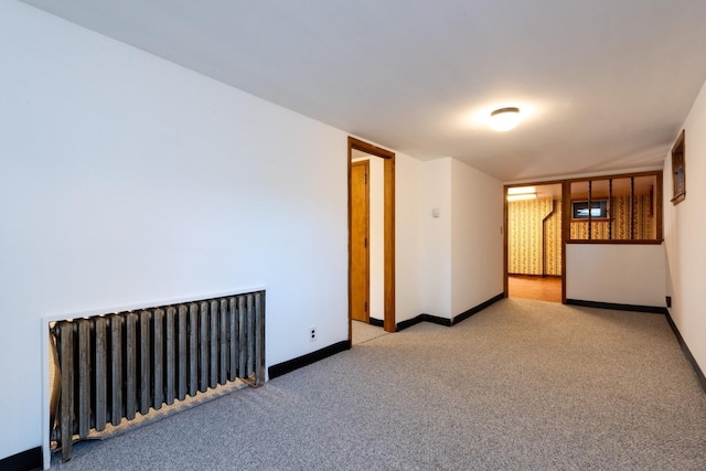 carpeted empty room with radiator heating unit