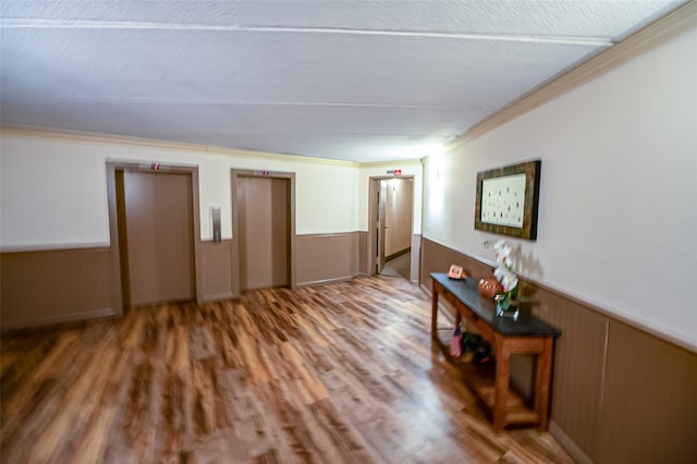 135 Post Ave Unit 5U, Westbury, NY 11590 - living area featuring elevator, a wainscoted wall, ornamental molding, and wood finished floors