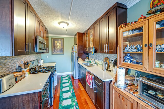 135 Post Ave Unit 5U, Westbury, NY 11590 - kitchen featuring stainless steel appliances, a sink, light countertops, backsplash, and wood finished floors