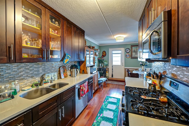 135 Post Ave Unit 5U, Westbury, NY 11590 - kitchen with stainless steel appliances, a sink, light countertops, dark wood-type flooring, and ornamental molding