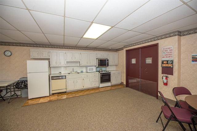 135 Post Ave Unit 5U, Westbury, NY 11590 - kitchen with white appliances, a sink, carpet floors, a drop ceiling, and light countertops