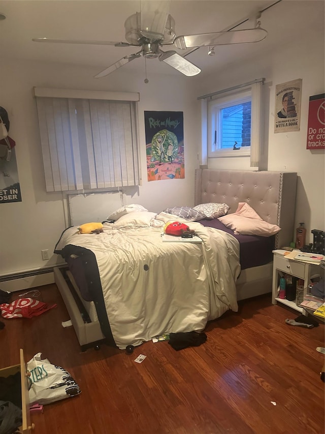 bedroom with ceiling fan, wood-type flooring, and baseboard heating