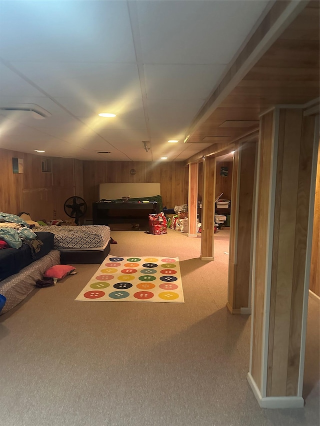 basement with carpet flooring and wood walls