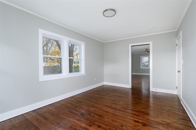 empty room featuring dark wood-type flooring and ornamental molding