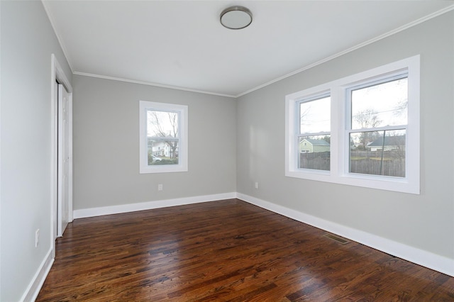 empty room with dark hardwood / wood-style flooring and ornamental molding