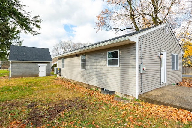 view of side of home with a yard and central AC unit