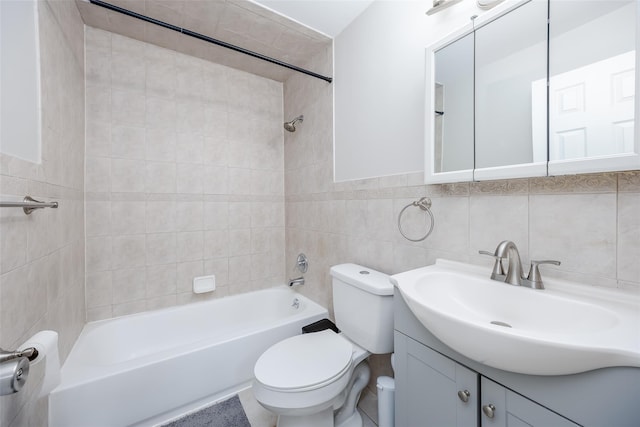 full bathroom featuring tile patterned floors, toilet, vanity, tile walls, and tiled shower / bath