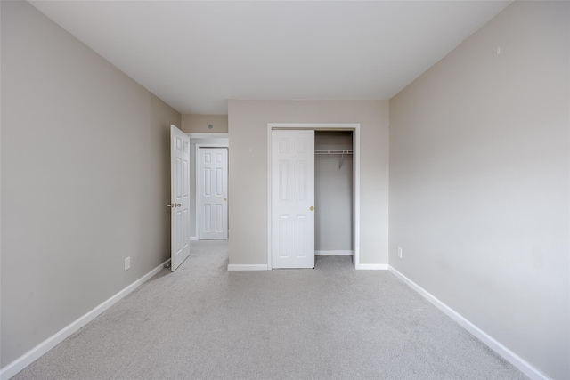 unfurnished bedroom with light colored carpet and a closet