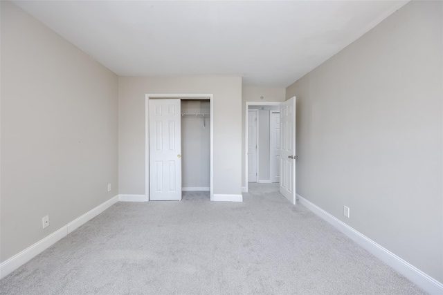 unfurnished bedroom featuring a closet and light colored carpet